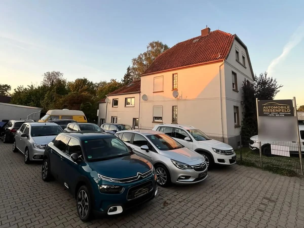 Unser Hof an der Werler Straße mit vielen Gebrauchtwagen und Firmenschild im Abendlicht